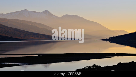 Ben Cruachan in warm sunset light reflects in the calm waters of Loch ...