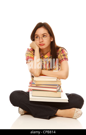 Pretty coed thinking with a pile of books on white background. ('Coed with books' photo series – exclusive to Alamy) Stock Photo