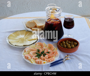 A selection of tapas with sangria and beer, King prawns with lemon, Sliced Manchego cheese, and green olive cocktail, Spain. Stock Photo