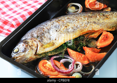 Herb-stuffed trout with tomatoes and onion Stock Photo