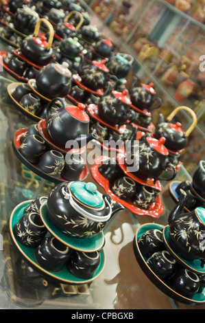 Vertical angular view of rows and rows of traditional Vietnamese teapots and cups for sale in pottery shop. Stock Photo