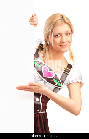 A portrait of a woman in traditional bavarian costume holding a white panel isolated on white background Stock Photo