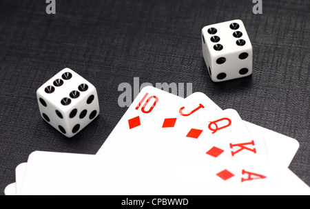 Two white dices and playing cards on a black background Stock Photo