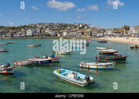 St. Ives habour boats floating on shallow clear sea water. Stock Photo