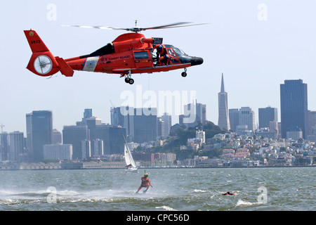 A swimmer is lowered to the waters of San Francisco Bay by a United States Coast Guard HH-65C Dolphin helicopter. Stock Photo