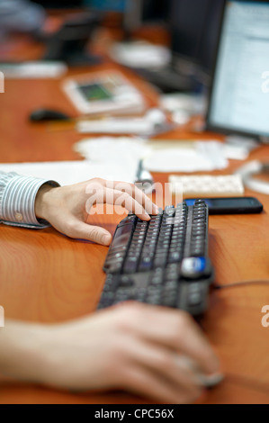 Close up of person's hands on a mouse and keyboard. Stock Photo