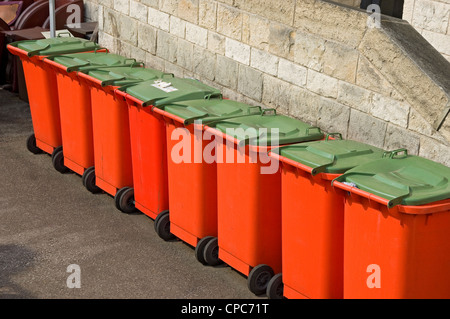 Row line of commercial large rubbish garbage waste wheelie bin bins container containers outside hotel England UK United Kingdom GB Great Britain Stock Photo