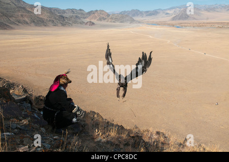 A Kazakh eagle hunter lets his golden eagle fly in the Altai Region of Bayan-Ölgii in Western Mongolia Stock Photo