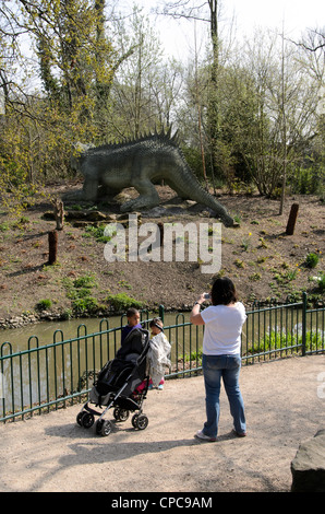 Mother taking a photo of his children -Crystal Palace Parks prehistoric monster trail - Sydenham, London - England Stock Photo