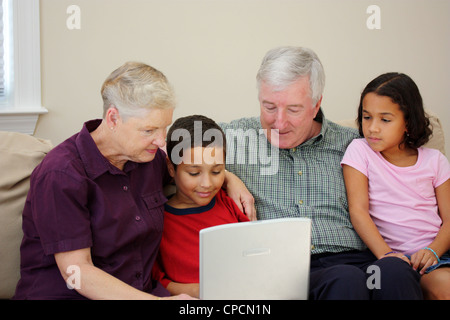 Grandparents together with their family at home Stock Photo