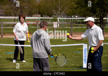 Young boy having tennis coaching, Newmarket Suffolk UK Stock Photo