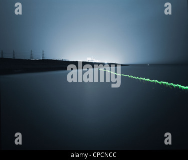 Light trails over still water at night Stock Photo