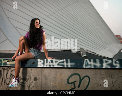 Woman sitting on gratified wall Stock Photo