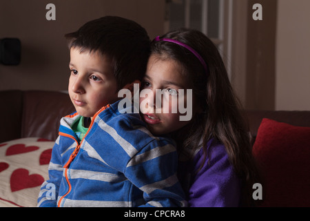 Siblings ,brother and sister watching TV together Stock Photo