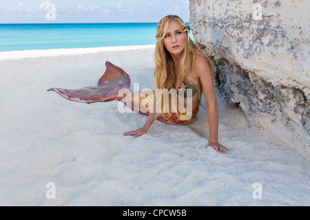 Young blond mermaid laying on the beach in Cancun, Mexico Stock Photo