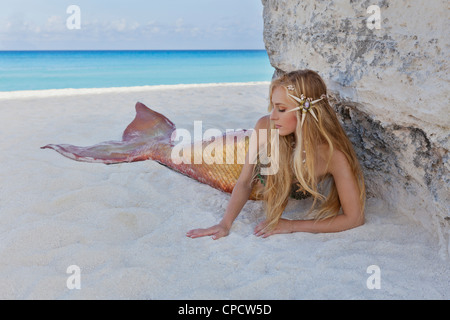 Young blond mermaid laying on the beach in Cancun, Mexico Stock Photo