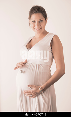 Pregnant woman holding hand with miniature disco ball on her stomach Stock Photo