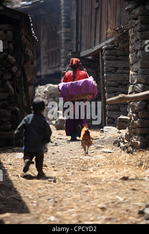 Mother carrying her child in the Tamang village - Nepal Stock Photo