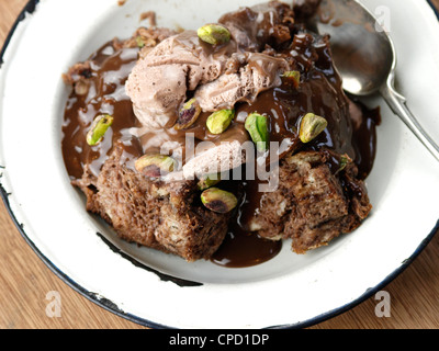 Chocolate bread and butter pudding with Chocolate Icecream, Chocolate Sauce and Pistachio Nuts Stock Photo