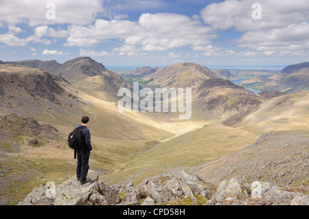 Walker on summit of Green Gable in the English Lake District, looking down Ennerdale Valley towards Pillar and Haystacks Stock Photo
