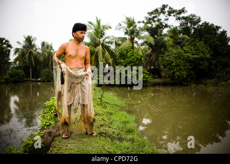 A fisherman in Bangladesh prepares to cast his fishing net in pond Stock Photo