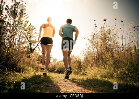 Caucasian couple running together on path Stock Photo