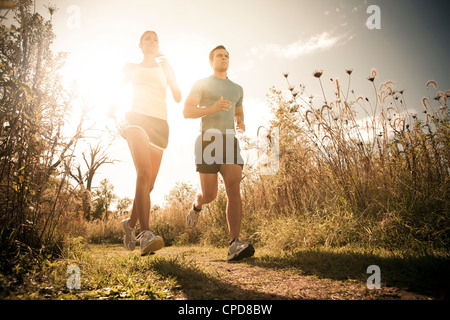 Caucasian couple running together on path Stock Photo