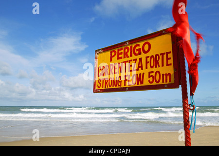 Brazil empty beach warning sign for strong current and rip tide sand dune landscape sunny day with blue sky Stock Photo