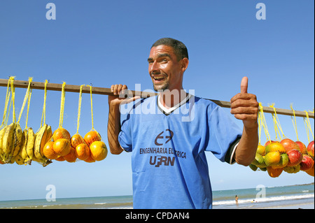 Brazil Natal happy smiling man vendor selling tropical fruit on beach sunny day with blue sky Stock Photo