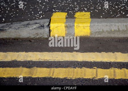 double yellow lines road and no loading kerb pavement markings in Glasgow Scotland UK Stock Photo