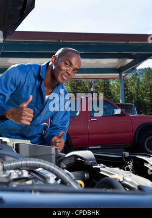 Black mechanic working on car engine Stock Photo