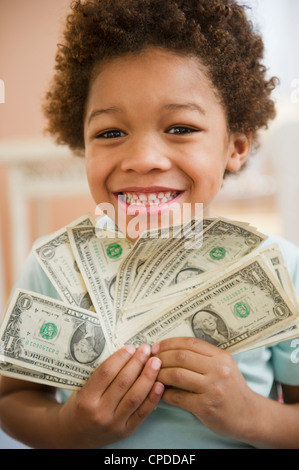 Black boy holding one dollar bills Stock Photo