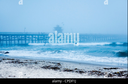 San Clemente pier with surfers on a foggy day, California, United States of America, North America Stock Photo