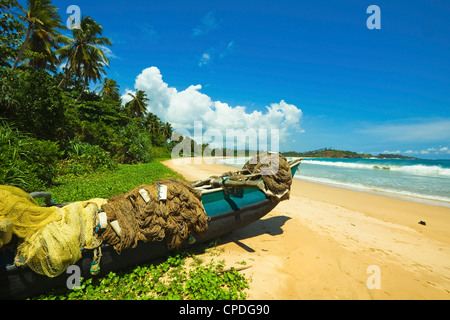 Outrigger fishing boat and nets at this quiet south coast retreat beach, Talalla, near Matara, Southern Province, Sri Lanka Stock Photo