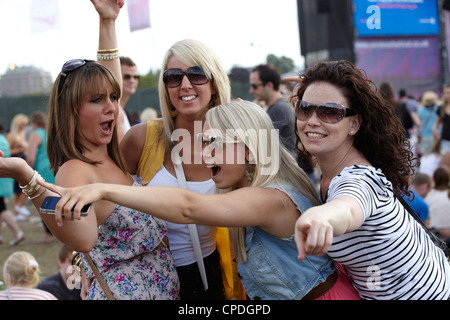Group of girls walking along laughing at a music festival Stock Photo ...
