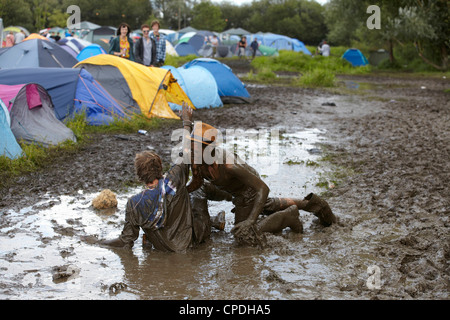 Boys playing in mud at music festival in the UK Stock Photo