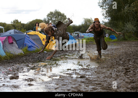 Boys playing in mud at music festival in the UK Stock Photo