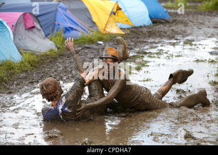 Boys playing in mud at music festival in the UK Stock Photo