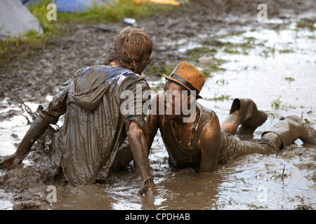 Boys playing in mud at music festival in the UK Stock Photo