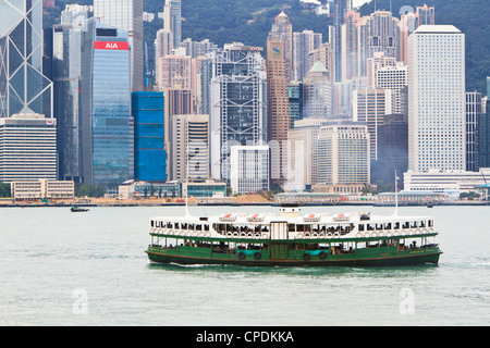 Star ferry crosses Victoria Harbour with Hong Kong Island skyline behind, Hong Kong, China, Asia Stock Photo