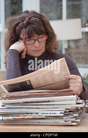 middle aged woman reading newspapers Stock Photo