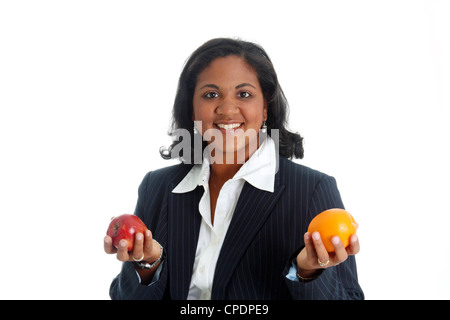 Woman comparing apples and oranges on a white background Stock Photo