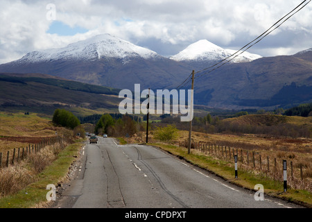 a82 trunk road through the scottish highlands with snow covered mountains ben more left and stobinian near tyndrum Scotland UK Stock Photo
