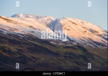 Shaft of golden sunlight on a snowy covered mountain, Glen Sheil, Highlands, Scotland, UK Stock Photo