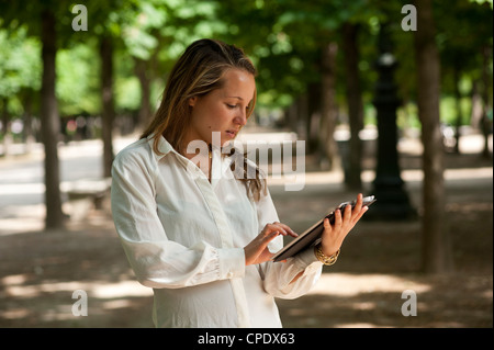 Young woman holding a digital tablet outdoors. Stock Photo