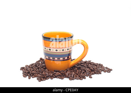 Colorful coffee cup surrounded by loose roasted coffee beans cut out on white background Stock Photo