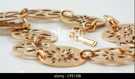 Golden bracelet of discs disk with tracery slot and with small medalion where you can place an ad or a logo. Stock Photo