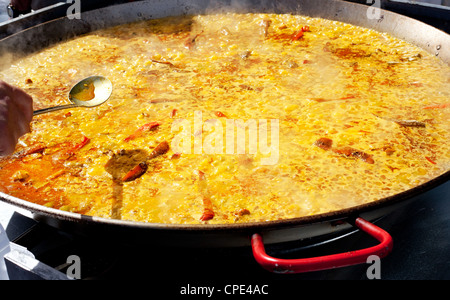 Paella rice typical from Valencia Spain cooking in big pan Stock Photo