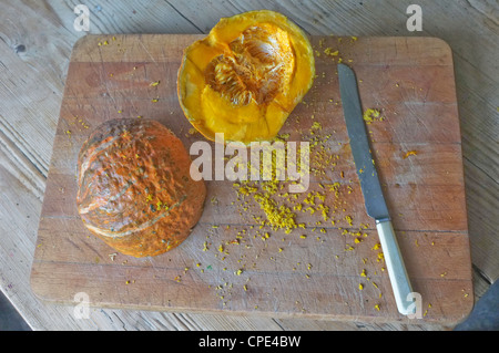A freshly cut pumpkin on a bread board Stock Photo