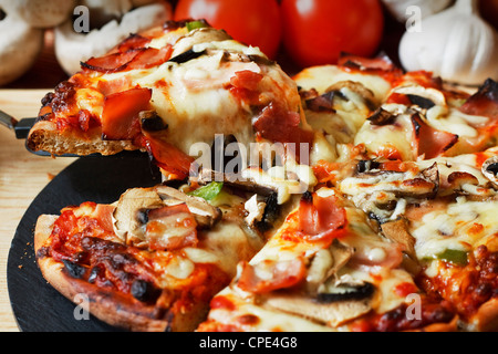 serving slice of ham and mushroom pizza with close up on stringy melted mozzarella cheese Stock Photo